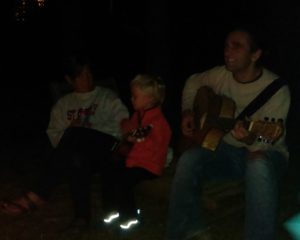 01-around-the-bonfire-ollie-plays-ukelele-while-uncle-justin-plays-guitar